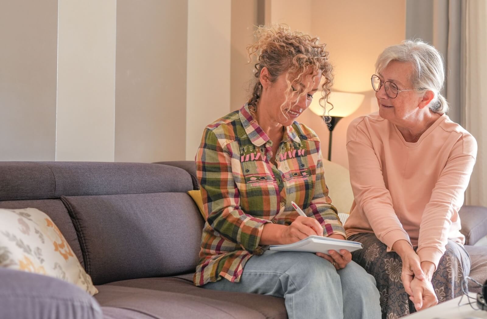 caregiver is taking notes while listening to their loved one with dementia